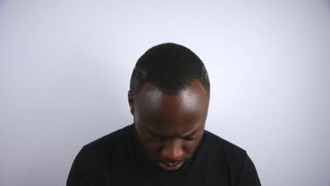 Black-Male-Slowly-Looking-Up-To-Camera-With-An-Angry-Expression-With-White-Background