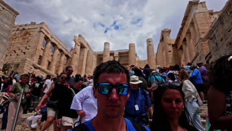 Young-man-vlogging-while-walking-in-crowded-Acropolis-of-Athens