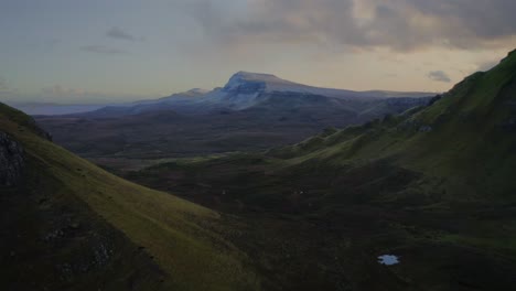 Die-üppigen-Grünen-Highlands-Auf-Dem-Quiraing-Walk-Und-Ein-Entfernter-Schneebedeckter-Berg,-Iske-Of-Skye,-Schottland