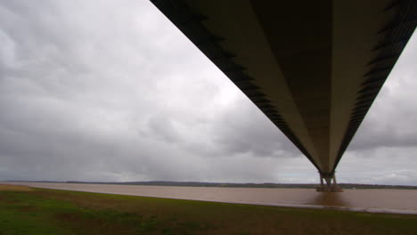 panning-shot-left-to-right,-looking-up-under-the-Humber-bridge-and-stopping-in-the-middle-on-the-south-shore