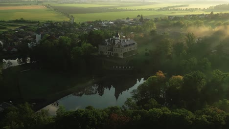 Adun-Castle-Bei-Sonnenaufgang,-Umgeben-Von-Morgennebel,-Der-Den-Riesigen-Park-Bedeckt