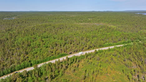 Aérea:-Caravana-Conduciendo-Por-Una-Carretera-Boreal-En-Medio-De-La-Interminable-Naturaleza-Salvaje-De-Laponia