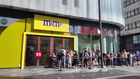 Gente-Haciendo-Cola-Para-Entrar-A-La-Tienda-M&amp;m&#39;s-En-Leicester-Square-Por-La-Mañana