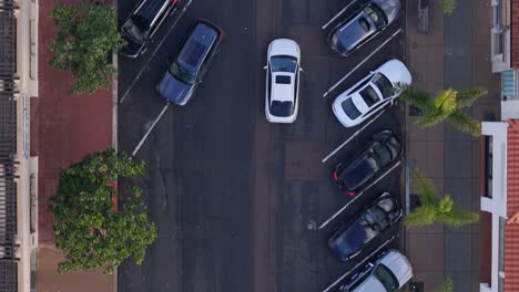 Vista-De-Arriba-Hacia-Abajo-Del-Dron-De-La-Calle-La-Jolla-Cove-Con-Autos-Estacionados,-Un-Auto-Blanco-Pasa-A-Través-Del-Marco-De-Abajo-Hacia-Arriba