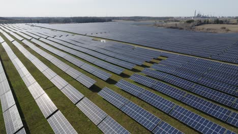 Expansive-solar-farm-with-rows-of-photovoltaic-panels-on-a-sunny-day,-aerial-view