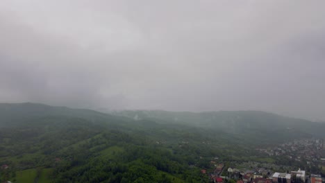 Imágenes-Cinematográficas-De-Drones-Aéreos-De-4k-Volando-En-Las-Nubes-De-Lluvia-Durante-La-Lluvia-En-La-Ciudad-Con-Montañas-En-El-Fondo