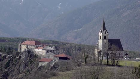 View-towards-Rodenegg-castle-and-the-parish-church-in-Vill,-Rodeneck---Villa-di-Rodengo,-South-Tyrol,-Italy-on-a-sunny-day