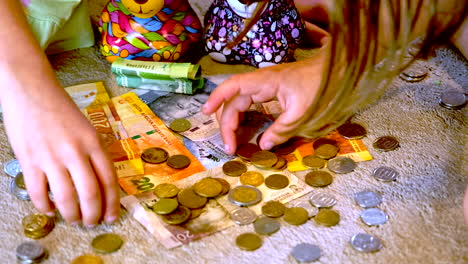 Closeup-view-of-siblings-counting-and-sorting-money-coins-of-South-African-rands