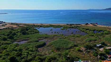 Agua-Azul-Del-Océano-Y-Pequeño-Pantano-Cerca-De-La-Playa,-Vista-Aérea-De-Drones