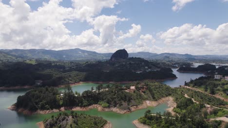 Drohne-Steigt-Mittags-über-Dem-Gewundenen-Fluss-In-El-Penon-De-Guatape,-Kolumbien-Auf