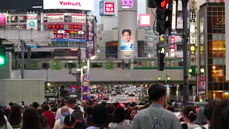 Cinematic-POV-walking-shot-through-streets-of-Tokyo-at-night-with-trains-and-people