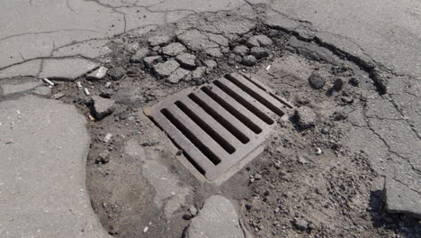 Asfalto-Roto-Alrededor-De-La-Alcantarilla-De-Drenaje-De-Lluvia-En-Las-Calles-De-La-Ciudad