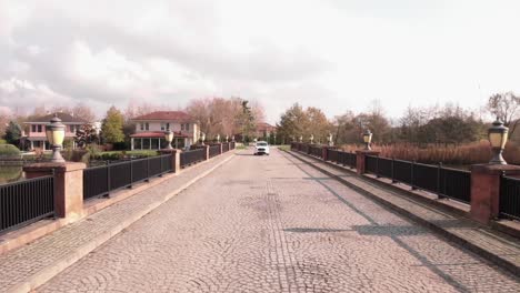 Luftaufnahme-Eines-Autos,-Das-Auf-Einer-Brücke-In-Einer-Wohnstraße-Fährt,-Omerli-Villen-In-Istanbul