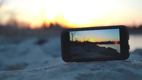 Ein-IPhone-Auf-Einem-Felsen,-Das-Eine-Zeitrafferaufnahme-Des-Sonnenuntergangs-Aufzeichnet