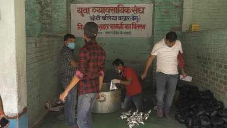 A-wide-shot-of-Indian-Citizens-of-a-Rural-Town-in-Bihar-preparing-food-packets-for-the-migrants,-daily-wagers-and-homeless-during-the-Coronavirus-Lockdown-imposition