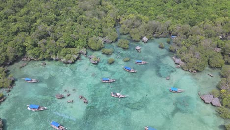 Up-crane-view-of-Zanzibar-fishing-boats-in-turquoise-Kwale-Island-lagoon