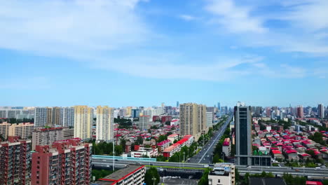 Blick-Auf-Den-Autoverkehr-Auf-Kreuzungen-Und-Autobahnkreuzen-In-Einer-Modernen-Stadt-Mit-Skyline-Wolkenkratzern-Und-Wahrzeichen-Unter-Blauem-Himmel,-Zeitraffervideo-Einer-Brücke