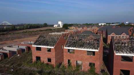 Residential-housing-estate-properties-with-unfinished-roof-on-building-site-development-land-in-recession-aerial-push-in-over-rooftop