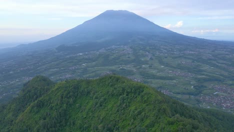 Vista-Aérea-De-Las-Laderas-De-Las-Montañas-Con-Vegetación-Forestal-Con-Vistas-A-Una-Enorme-Montaña.