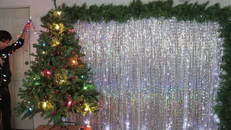Christmas-tree-decorations,-with-a-backdrop-of-shimmering-silver-streamers-as-home-decor