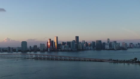 Aerial-shot-rising-from-the-ocean-while-viewing-downtown-Miami-at-sunset