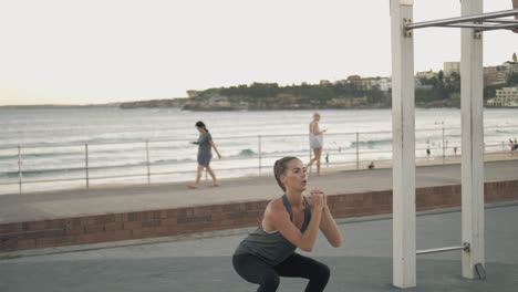 Hot-model-on-sunset-stretching-at-the-gym-by-the-ocean-slow-motion