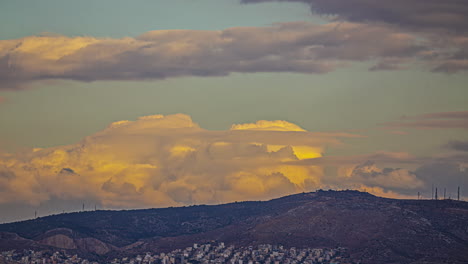 Orange-tone-clouds-flowing-above-mountains-and-city-of-Athens,-time-lapse