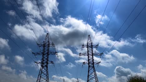 Two-transmission-towers-symmetrically-next-to-each-other-during-sunny-day-with-clouds