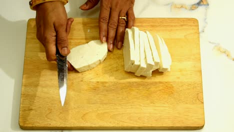 Cerca-De-Un-Paneer-De-Requesón-Cortado-Por-Una-Mujer-India