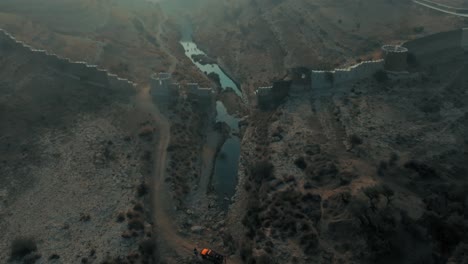 Alto-Vuelo-De-Drones-En-El-Fuerte-Ranikot-En-Sindh,-Pakistán,-Sobre-El-Río-Cerca-De-Ruinas-Históricas