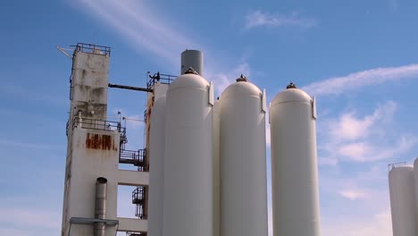 Die-Spitze-Einiger-Industriesilos-An-Einem-Tag-Mit-Blauem-Himmel-Und-Wolken