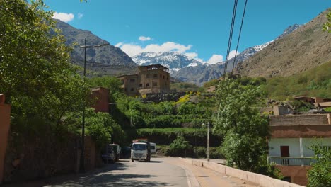 White-truck-drives-up-the-road-in-Imlil-village-with-Toubkal-in-the-background