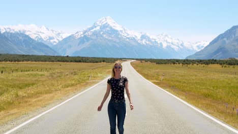 Lady-with-arms-out-stretched-looking-towards-snow-capped-Mountain-before-turning