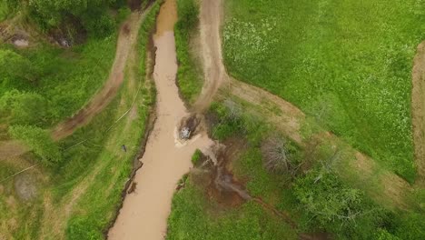 Offroad-mud-rally-with-buggy-in-forests-and-river-aerial-view