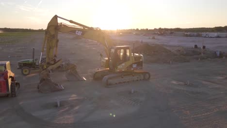 Drone-circling-around-a-parked-CAT-excavator-in-construction-site