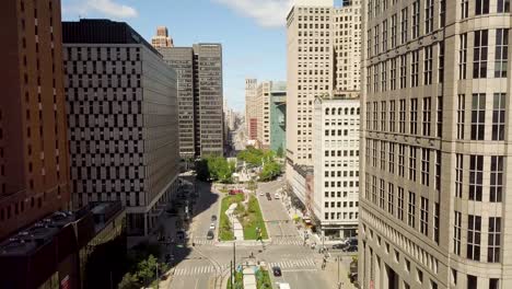 4K-Luftbildvideo-Der-Woodward-Avenue-In-Der-Innenstadt-Von-Detroit-Im-Sommer-2018-Mit-Fahrenden-Autos-Und-Spaziergängern-An-Einem-Sonnigen-Tag