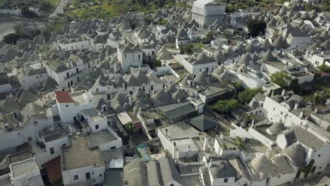 Beautiful-aerial-drone-footage-of-a-fourteenth-to-sixteenth-century-UNESCO-heritage-site-in-Alberobello,-at-the-South-of-Italy-showcasing-the-whitewashed-Trulli-and-their-handmade-symbolic-pinnacles