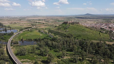 Eine-Drohne-Fliegt-über-Medellín-Und-Badajoz-Und-Enthüllt-Die-Alte-Burg,-Den-Mäandernden-Fluss-Und-Die-Malerische-Landschaft