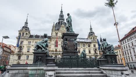 Hyperlapse-at-the-main-square-next-to-the-town-hall-in-Graz,-Austria,-4k-UHD,-Hyperlapse-of-an-old-statue-surrounded-by-historic-buildings