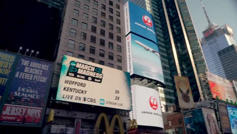 Vista-Giratoria-De-ángulo-Bajo-De-Las-Vallas-Publicitarias-Y-Anuncios-Digitales-En-Times-Square,-Nueva-York