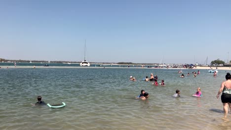 Schwenkaufnahme-Des-Strandes-An-Der-Goldküste-Mit-Einer-Frau,-Die-Auf-Der-Suche