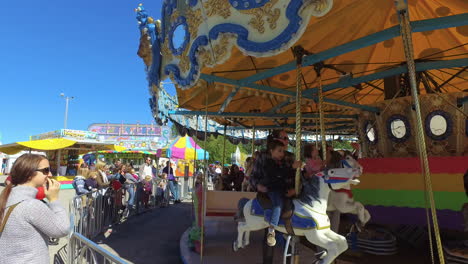 Herbstmesse-Mittlere-Aufnahme-Schwenks-Zusammen-Mit-Karussell-Als-Kinder-Und-Erwachsene-Fahren-Es