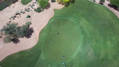 Aerial-golfer-walks-up-to-the-hole-as-another-golfer-prepares-to-putt,-Westin-Kierland-Golf-Course,-Scottsdale,-Arizona-Concept:-exercise,-charity,-tourism