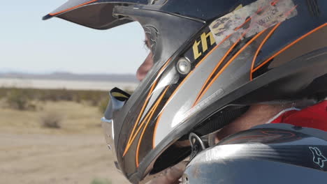 Cámara-Lenta:-Foto-Por-Encima-Del-Hombro-De-Un-Motociclista-En-El-Desierto-Antes-De-Comenzar-La-Carrera