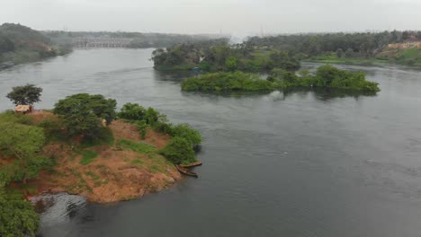 Toma-Aérea-Volando-A-Lo-Largo-Del-Río-Nilo-Con-La-Presa-De-Owen-Falls-En-La-Distancia