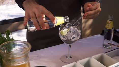 Porto,-Portugal---May-22,-2019:-Professional-bartender-preparing-a-Gin-Tonic-in-table-outside-during-summer