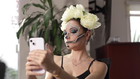 Mexikanisches-Model-Im-Catrina--Oder-Totenkopf-Frauenkostüm,-Das-Das-Endergebnis-Ihres-Make-ups-überprüft