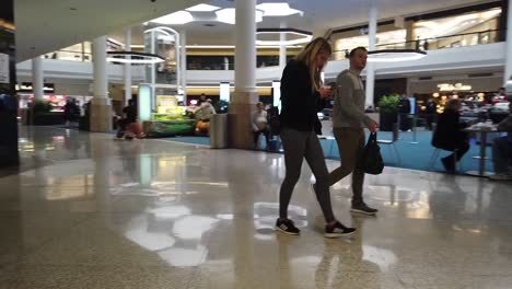 Happy-couple-walking-in-shopping-mall-with-bags