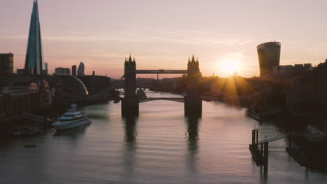 Aerial-View-of-London,-including-Towerbridge,-the-Shard,-and-the-river-Thames-as-the-sunsets