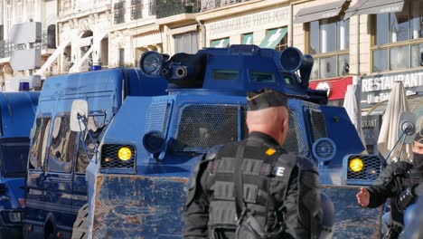 Ein-Polizist-Vor-Einem-Blauen-Panzer-Während-Einer-Gelbwesten-Demonstration-In-Marseille,-Südfrankreich